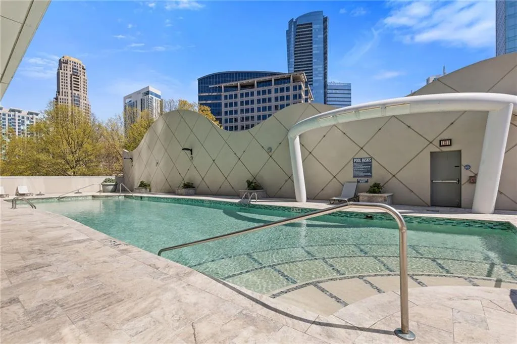 Community pool with a patio area and a view of city