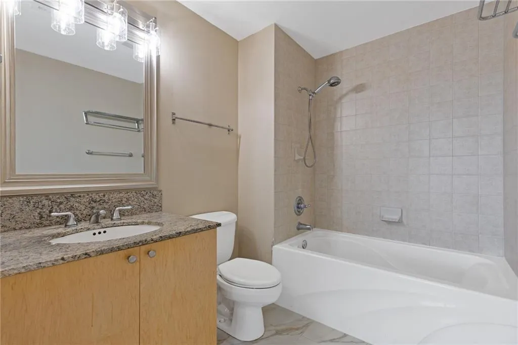 Bathroom with shower / washtub combination, vanity, and marble finish floors