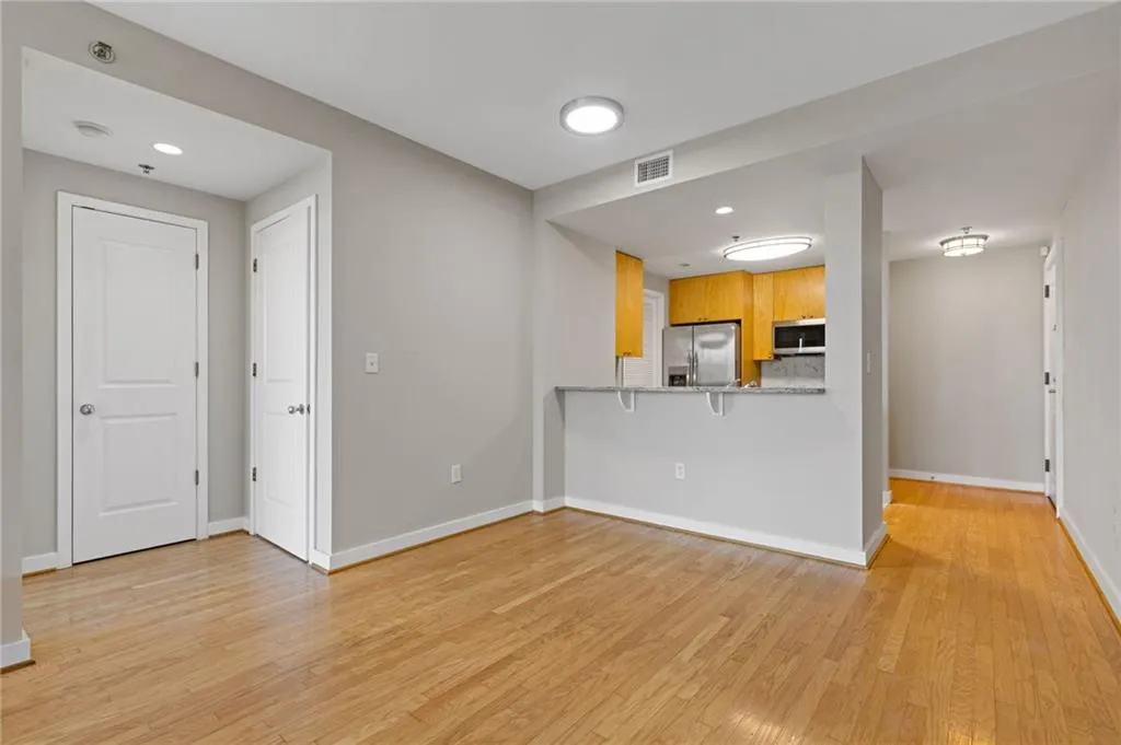 Kitchen with appliances with stainless steel finishes, light wood-style floors, a breakfast bar, and a peninsula