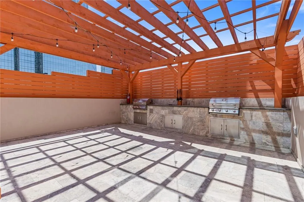 View of patio featuring an outdoor kitchen and a pergola