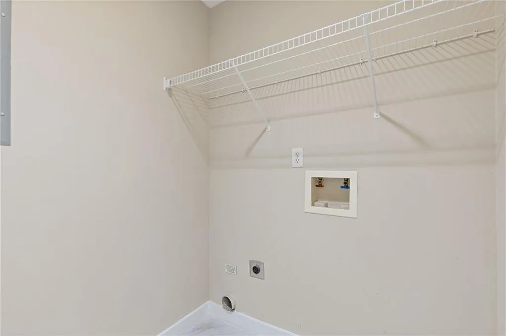 Laundry room with hookup for an electric dryer, hookup for a washing machine, and marble finish flooring