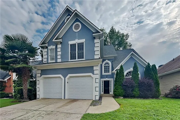 Striking two-story residence featuring a slate blue exterior with white trim and architectural detailing