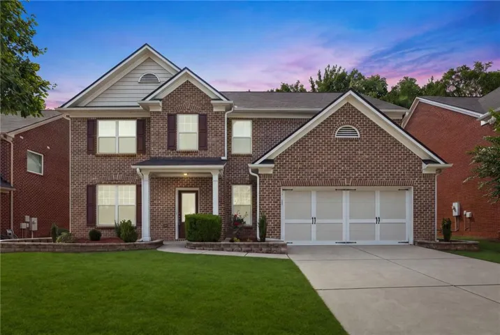Brick exterior with gabled roof lines, white trim, and dark shutters