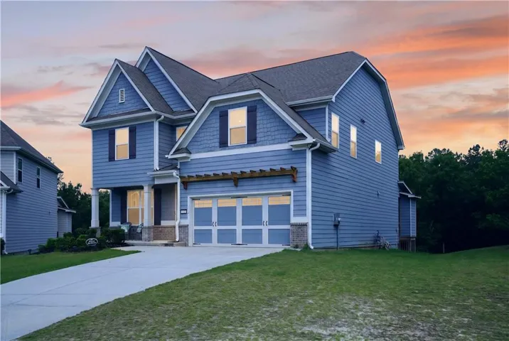 Elegant two-story colonial with blue fiber cement siding, multiple peaked rooflines, and architectural detail