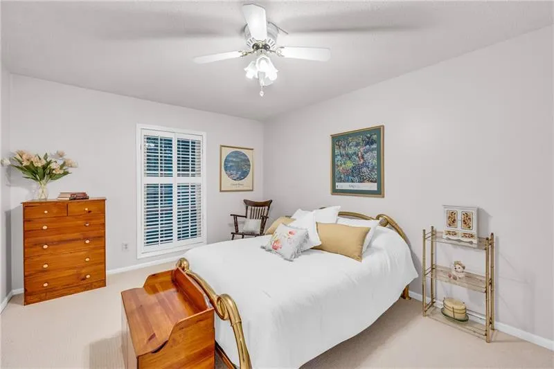 Bedroom with pristine carpet and ceiling fan