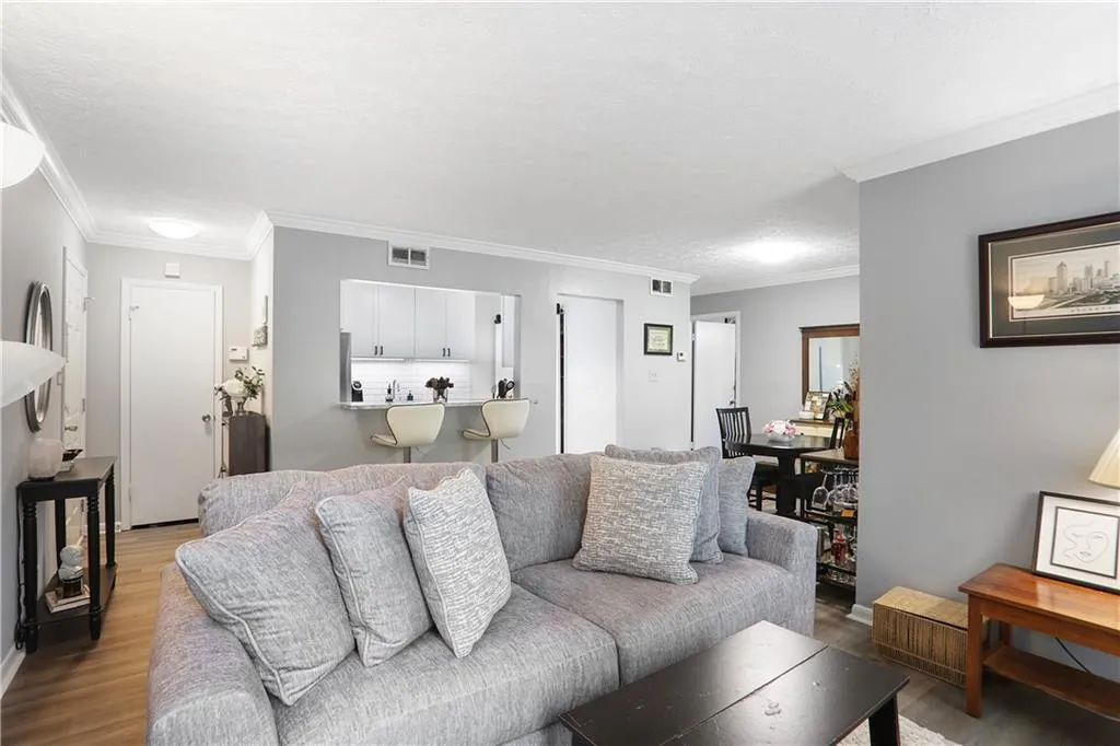 Living room featuring ornamental molding and light hardwood / wood-style floors