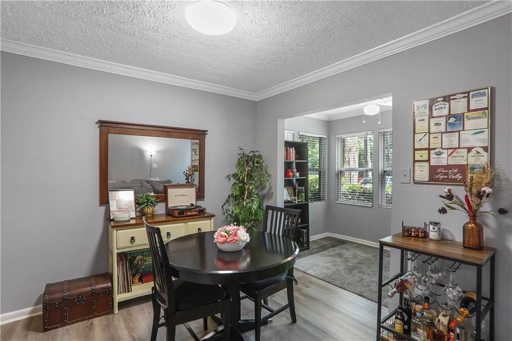 Dining area with crown molding, hardwood / wood-style flooring, and a textured ceiling