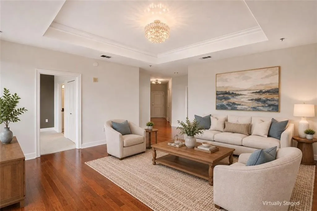 Hardwood flooring complemented by a tray ceiling with crown molding
