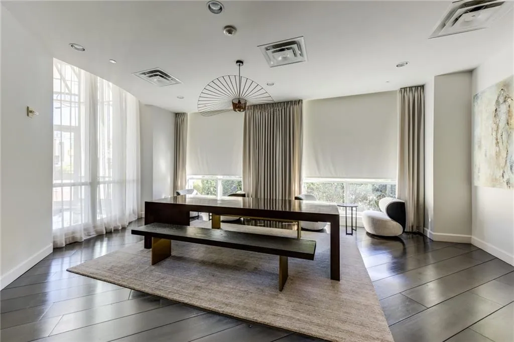 High ceilings with recessed lighting, dark wood-finish flooring, full-height windows, and contemporary light fixtures