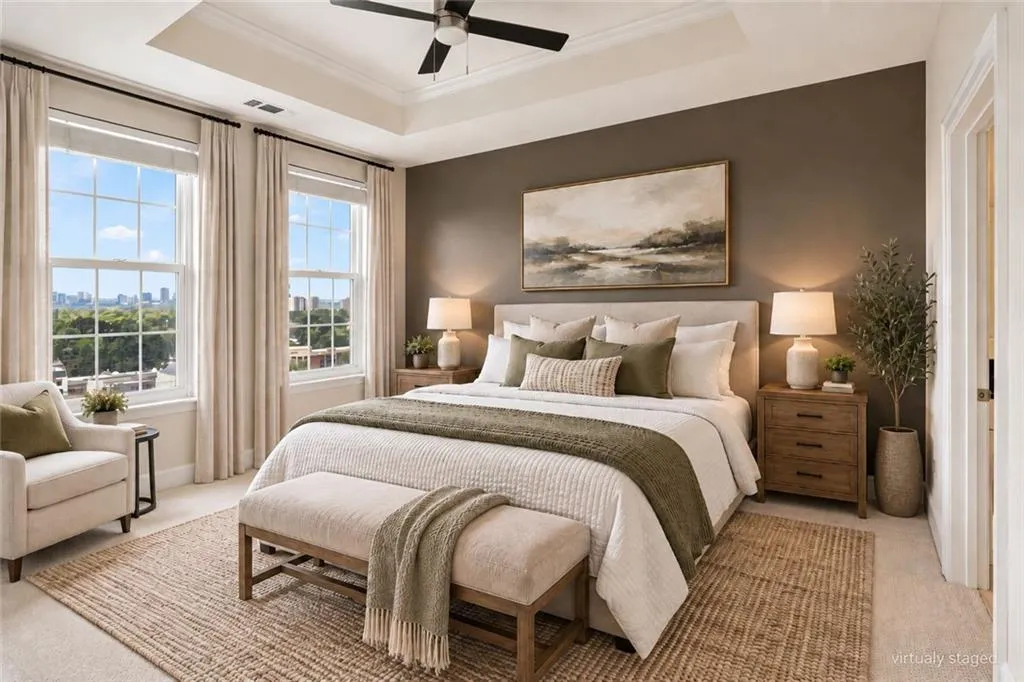 Tray ceiling with a ceiling fan, two large windows, and a panel door
