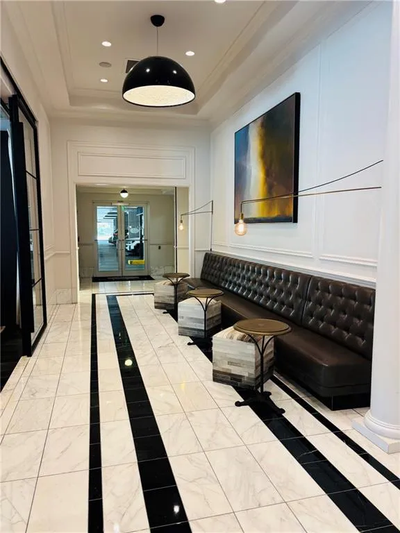 White and black tile flooring, recessed lighting, decorative wall paneling, a tufted benches, and a coffered ceiling and designer fixtures