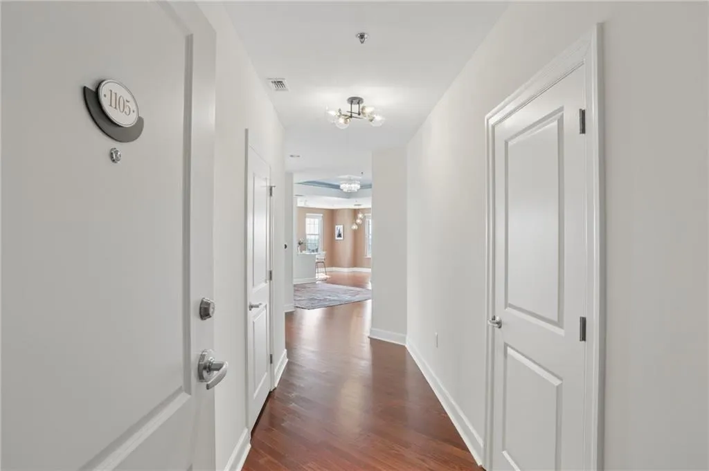 Entryway featuring wood-finish flooring, white panel doors, and recessed lighting