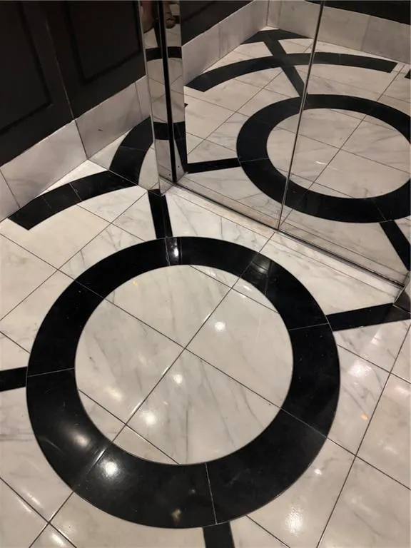 Custom marble tile flooring throughout building -Black and white tiled flooring with a circular pattern and polished finish even in the elevators!