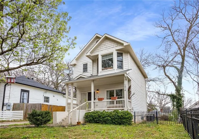 Two-story residence featuring white siding, a covered front porch, and a gable roofline
