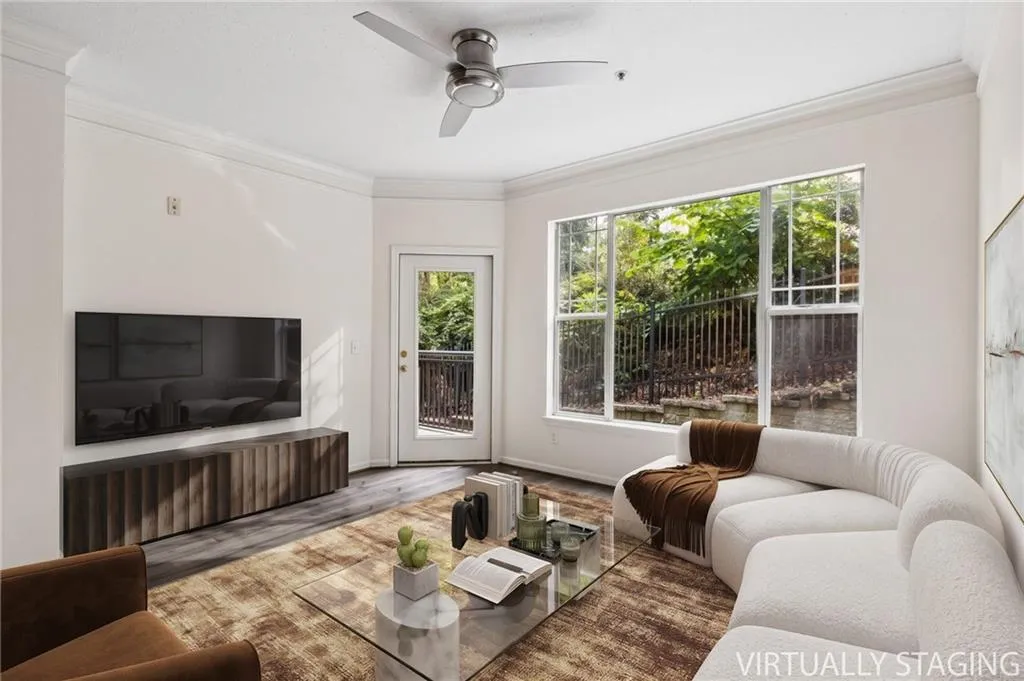Crown molding details, wood-finish flooring, a contemporary ceiling fan, and large picture windows