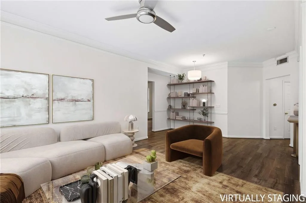 Wood-finish flooring, crown molding, a ceiling fan, built-in shelving, and a modern pendant light fixture