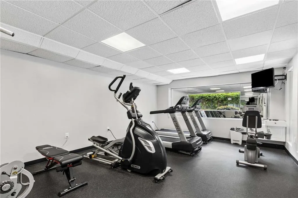 Dedicated fitness room featuring recessed lighting, a wide window, and durable rubber flooring