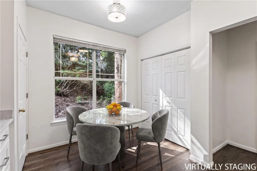 Window with exterior landscaping, dark wood-finish flooring, white bi-fold closet doors, and a decorative ceiling light fixture