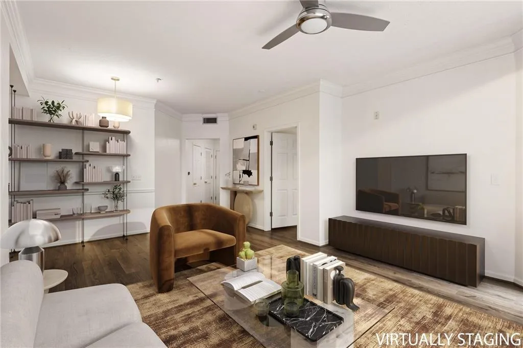 Wood-finish flooring, crown molding, built-in shelving, and a ceiling fan with integrated lighting