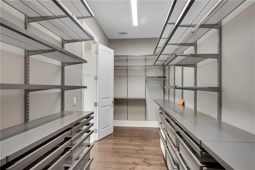 Walk in closet with light wood-type flooring