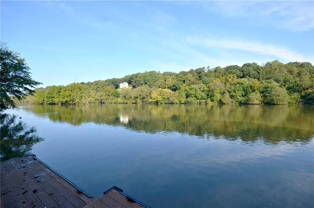 Dock area with a water view and a wooded view
