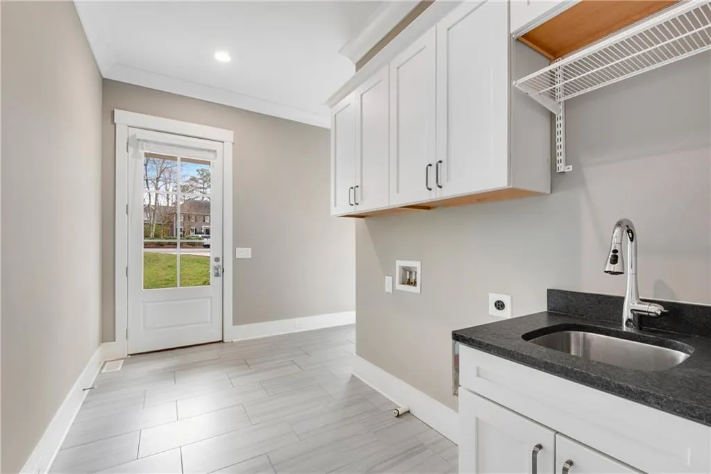 Laundry area with crown molding, washer hookup, hookup for an electric dryer, and cabinet space