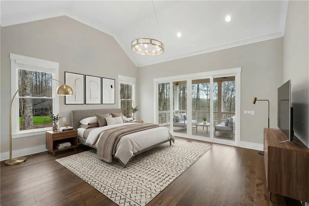 Bedroom featuring access to exterior, dark wood-style floors, vaulted ceiling, crown molding, and hanging lights