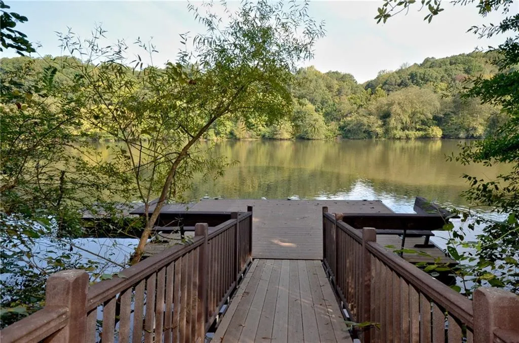 Dock area featuring a water view and a forest view