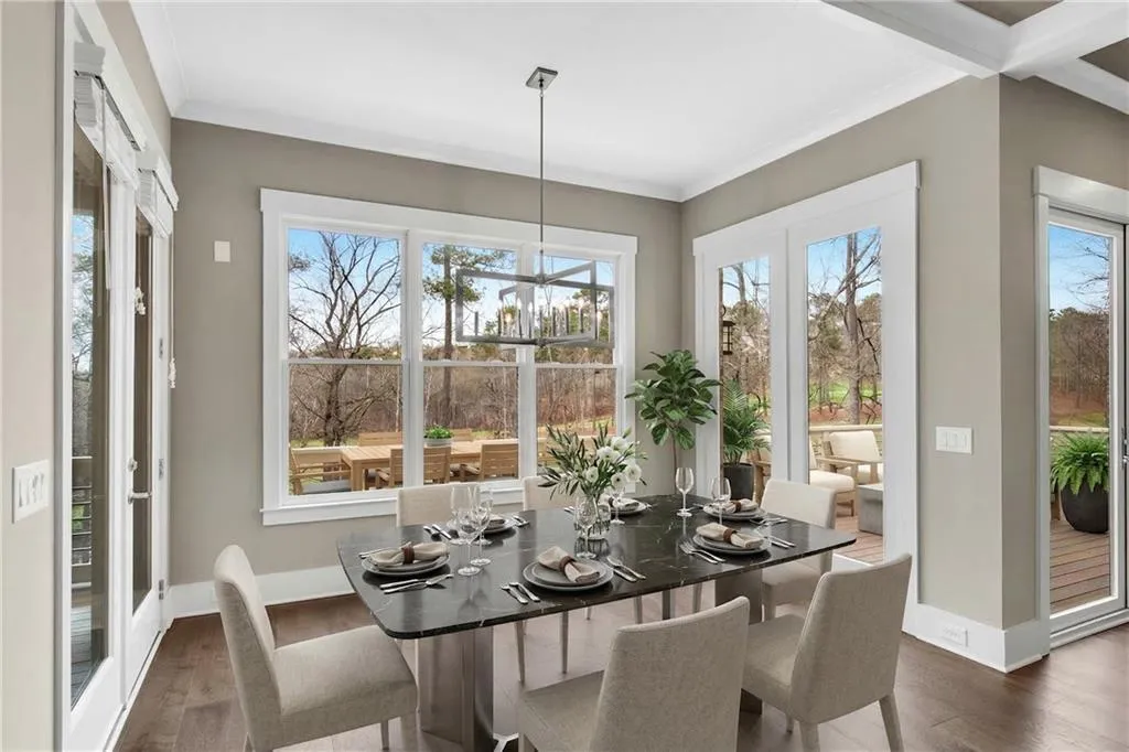 Dining area featuring dark wood-style flooring, suspended lighting, crown molding, and healthy amount of natural light