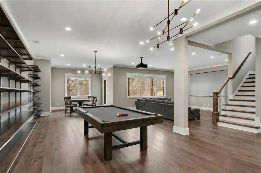 Rec room with billiards table, dark wood-style flooring, ornamental molding, and suspended lighting