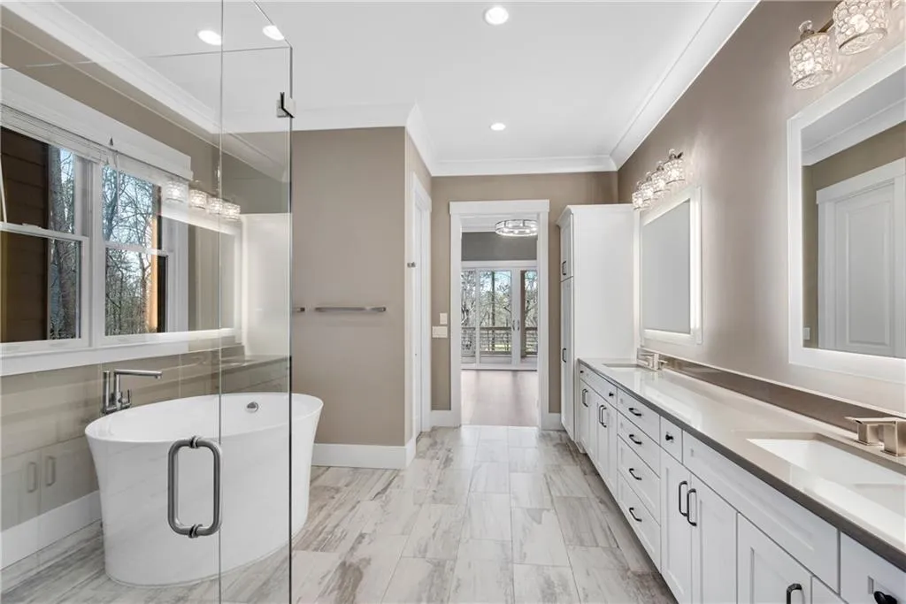 Full bath featuring double vanity, a freestanding bath, crown molding, and recessed lighting