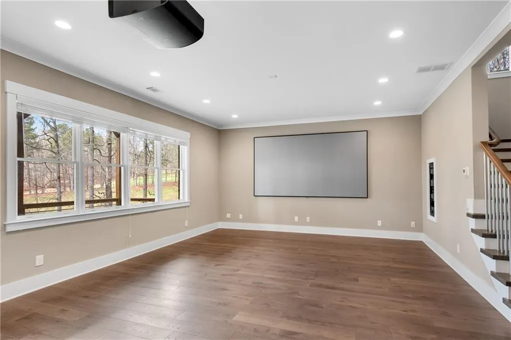 Home theater featuring crown molding, dark wood-style floors, and recessed lighting