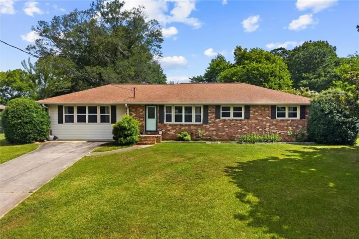 Brick and siding exterior with a brown shingle roof