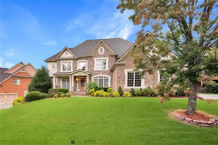 Brick exterior residence featuring a covered entry, multiple gables, and white-framed windows