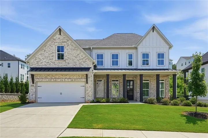 Brick and vertical siding exterior with a covered porch, attached two-car garage, and concrete driveway