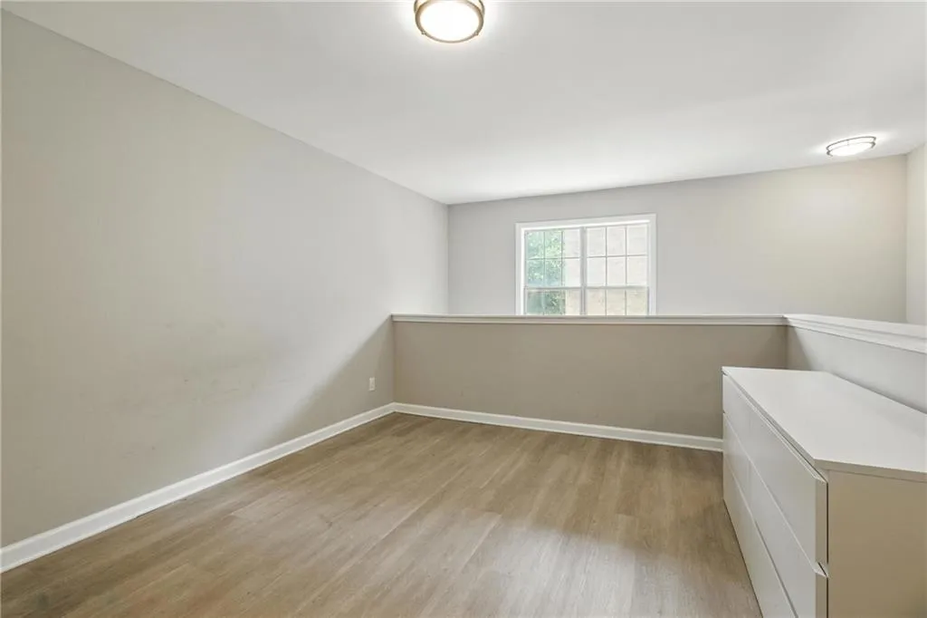 Unfurnished bedroom featuring wood finished floors and baseboards