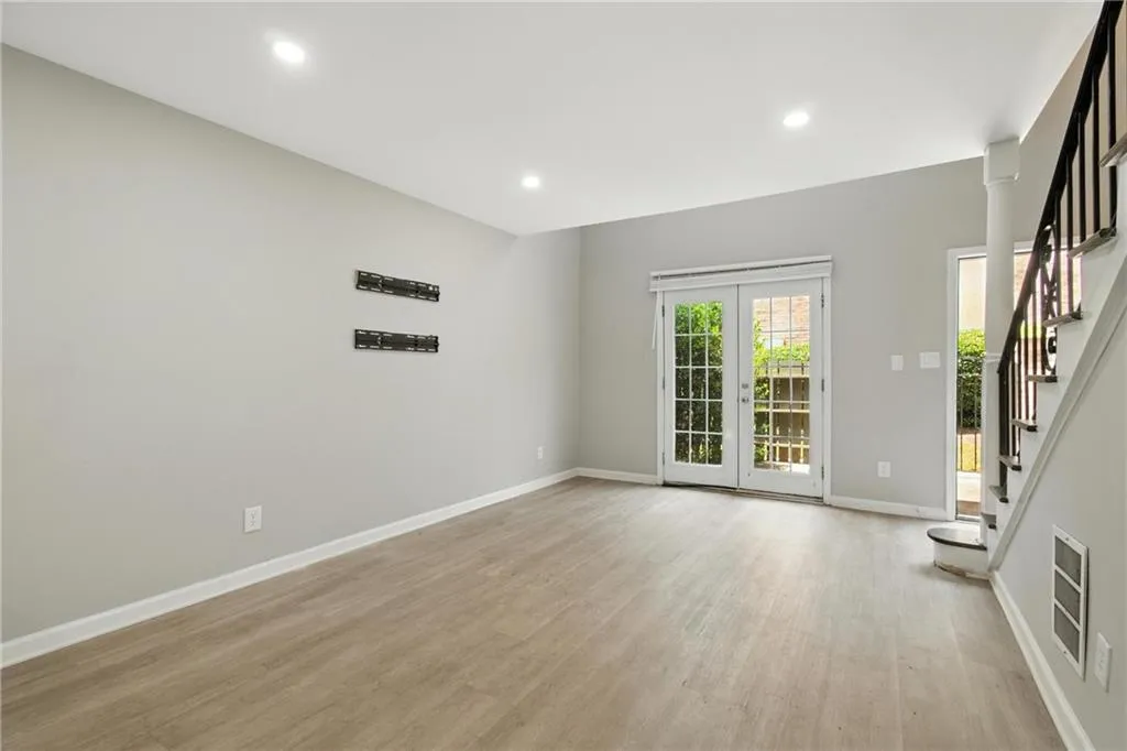 Unfurnished room featuring stairs, light wood-type flooring, recessed lighting, and heating unit