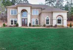 View of front facade with a front yard, french doors, and brick siding