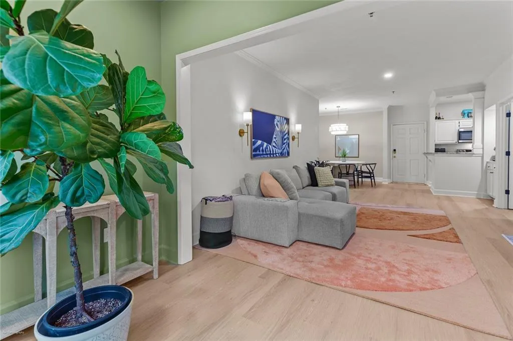Living area featuring light wood-type flooring, crown molding, and recessed lighting