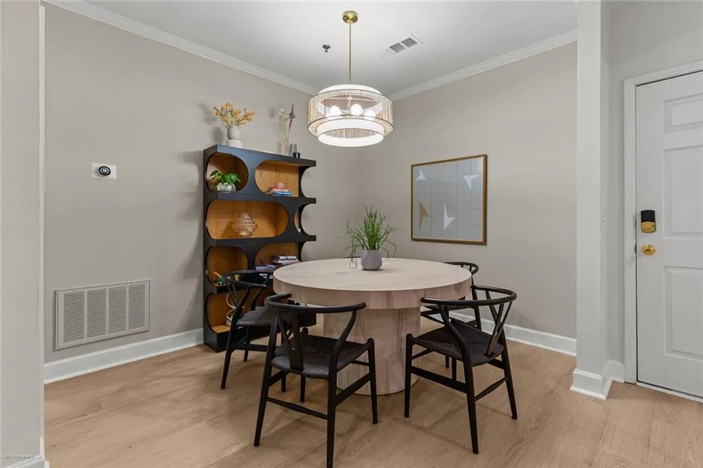 Dining space with ornamental molding and light wood-style flooring