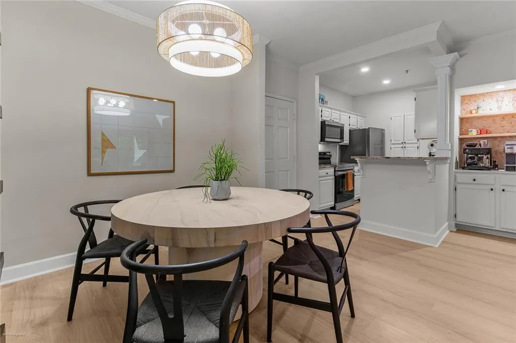 Dining space with ornamental molding, light wood finished floors, and recessed lighting