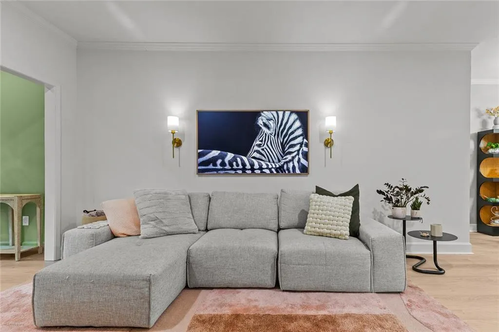 Living area with wood finished floors and ornamental molding