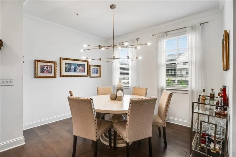 Dining area with crown molding, dark wood finished floors, and a chandelier