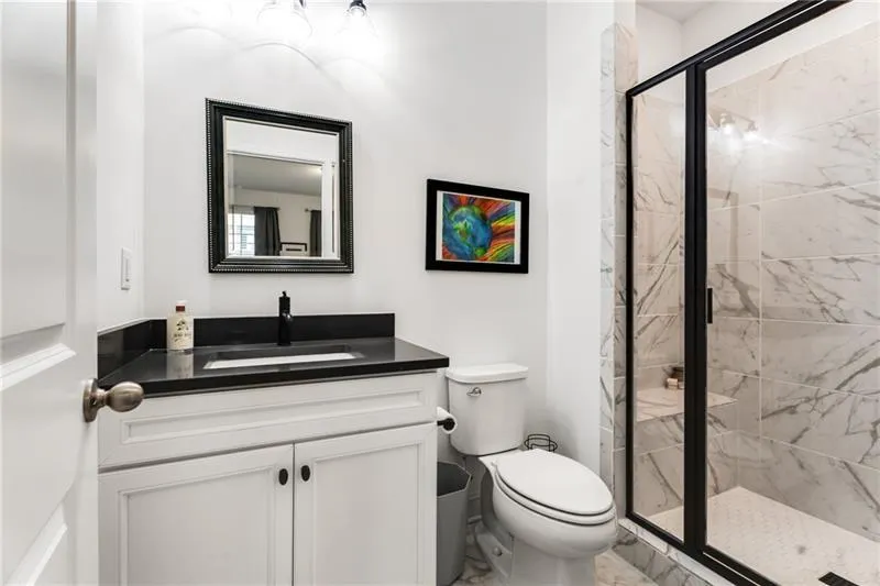 Full bath with a marble finish shower, vanity, and light marble finish floors