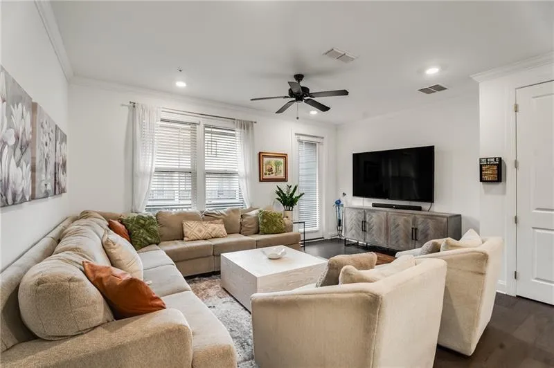 Living area with ornamental molding, wood finished floors, a ceiling fan, and recessed lighting