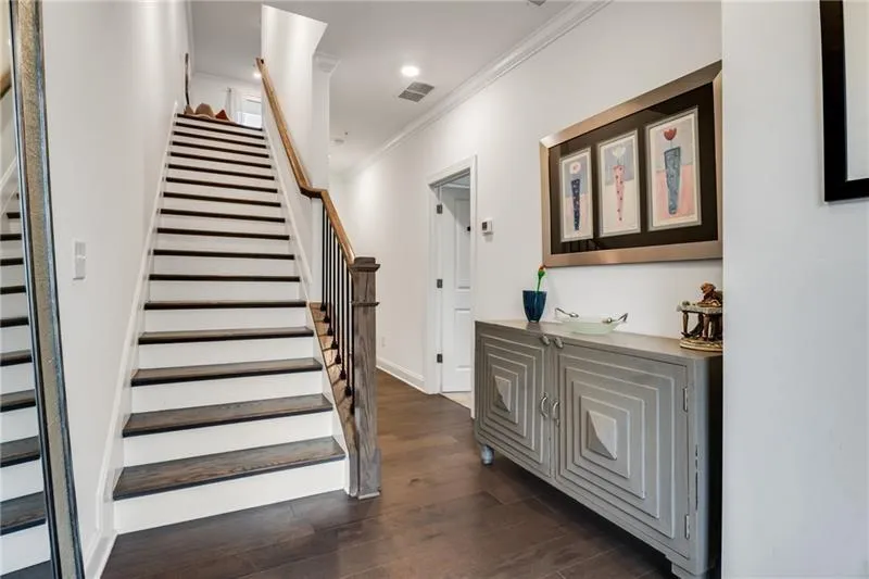 Stairway featuring crown molding, wood finished floors, and recessed lighting