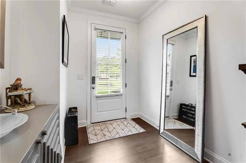Entrance foyer featuring ornamental molding and dark wood-style floors
