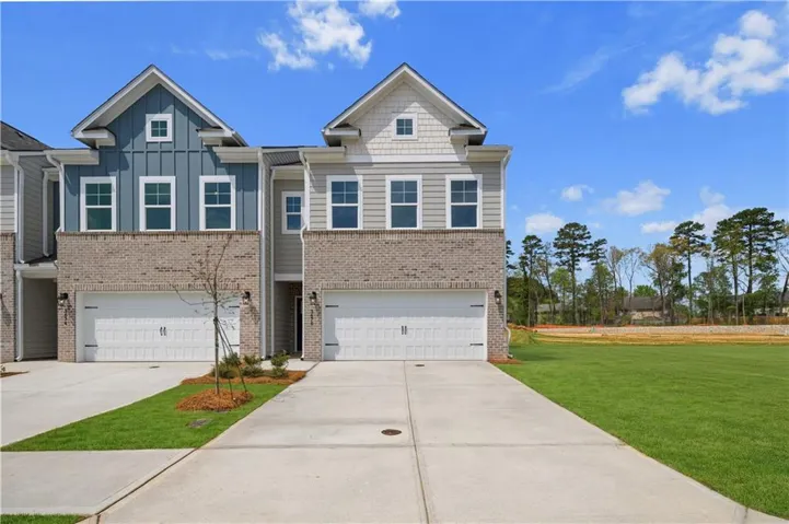 Contemporary townhome with brick and siding facade, two-car garage, and concrete driveway