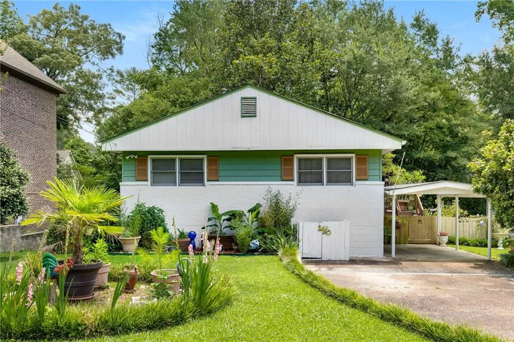 Bungalow-style home with brick siding, a carport, and concrete driveway