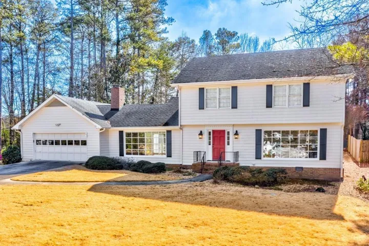 White siding exterior with a red entry door